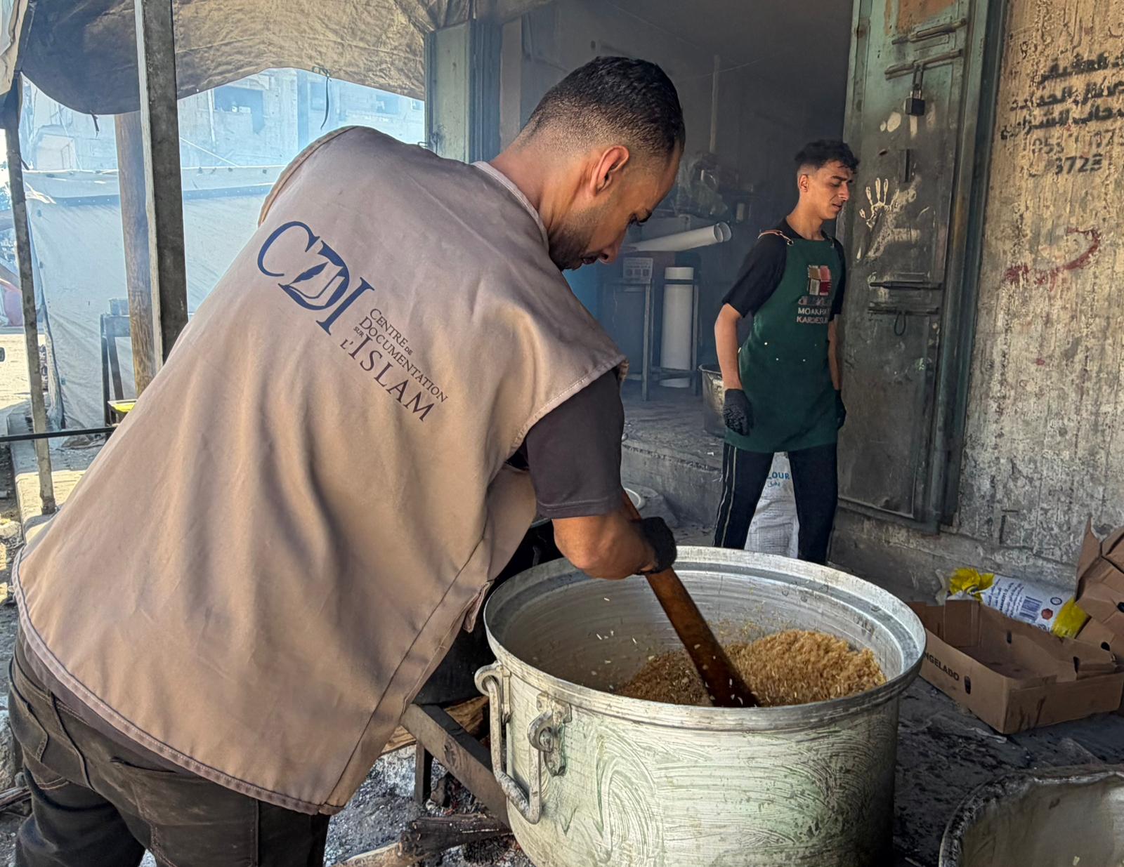 Humanitarian officer stirring a big pot of rice in Palestine